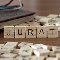 Scrabble tiles across a table with five balanced upright and spelling out the word Jurat