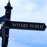 Signpost with the words Notary Public with blue skies in the background