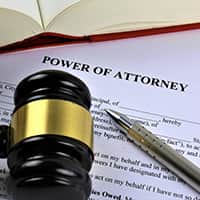 A closeup of a Power of Attorney form on a desk with a gavel and a pen